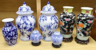 A pair of Japanese black ground vases, a pair of Chinese blue and white vases and covers, a