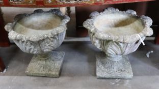 A pair of circular reconstituted stone garden planters moulded with acanthus leaves, diameter