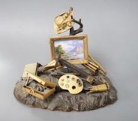 A 19th century Swiss gilt bronze, enamel, gem and paste mounted tableau of an artist's equipment,