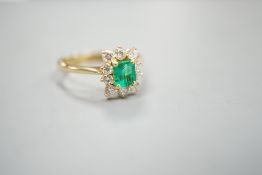 A 750 yellow metal, emerald and diamond set cluster ring, size m, gross weight 3.2 grams.