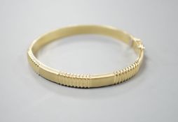 A modern 585 yellow metal hinged bangle, 12.8 grams.