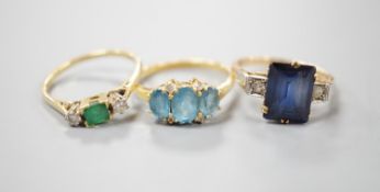 Three assorted 18ct and gem set dress rings, including emerald and diamond three stone, size Q/R,