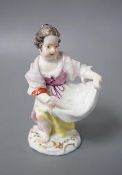An 18th century Meissen figure of a girl holding her apron to make a basket shape kneeling on the