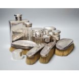 Six assorted George V silver mounted glass toilet jars, a similar brush set, a silver napkin ring