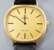A gentleman's gold plated Omega de Ville manual wind wrist watch, on a black leather strap, with
