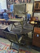 A set of four Westminster teak folding elbow chairs and a weathered teak circular garden table,