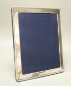 A modern silver photo frame,25 cms wide x 30 cms high.