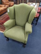 A George III style wing armchair upholstered in green wool fabric, width 86cm, depth 80cm, height