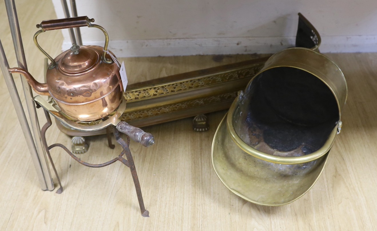 A copper kettle and trivet stand, a brass coal scuttle and a fender,Trivet 33 cms high.