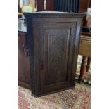 A George III later carved oak hanging corner cabinet, width 72cm, depth 42cm, height 105cm