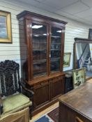 A Victorian mahogany bookcase fitted two drawers with panelled cupboard base, length 127cm, depth