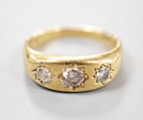 An 18ct gold and three stone gypsy set diamond ring, size S, gross weight 7.1 grams.