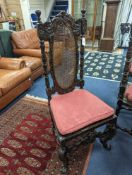 A set of six Charles II style carved oak dining room chairs with caned backs and seats and squab