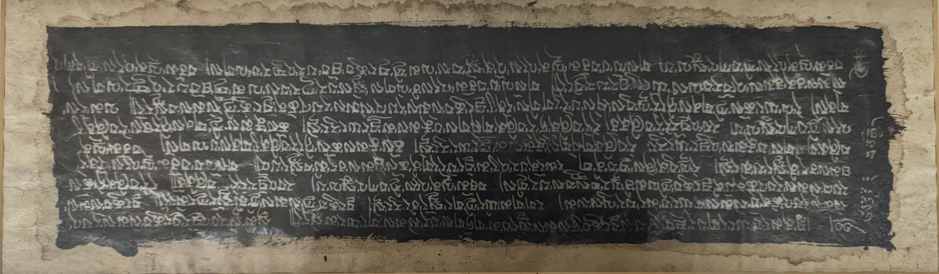 A framed Tibetan Sanskrit sutra panel,45cms x 13 cms.