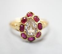 An early 20th century yellow metal and pear cut single stone diamond ring, with ruby set border,
