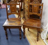 A pair of Victorian carved oak hall chairs