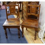 A pair of Victorian carved oak hall chairs