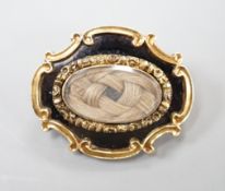 An early Victorian yellow metal, black enamel and plaited hair mourning brooch, inscribed verso, '
