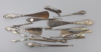 Four repousse silver handled shoe horns, seven similar button hooks, three nail implements, a pair