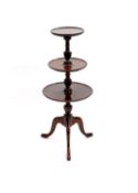 An Edwardian George III style mahogany three tier revolving dumb waiter, on cabriole tripod,