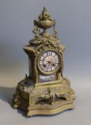 A 19th century French gilt metal and porcelain eight day mantel clock, with floral urn pediment,