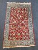 A Persian Qum red ground rug woven with animals and exotic birds among stylised flower heads 220 x