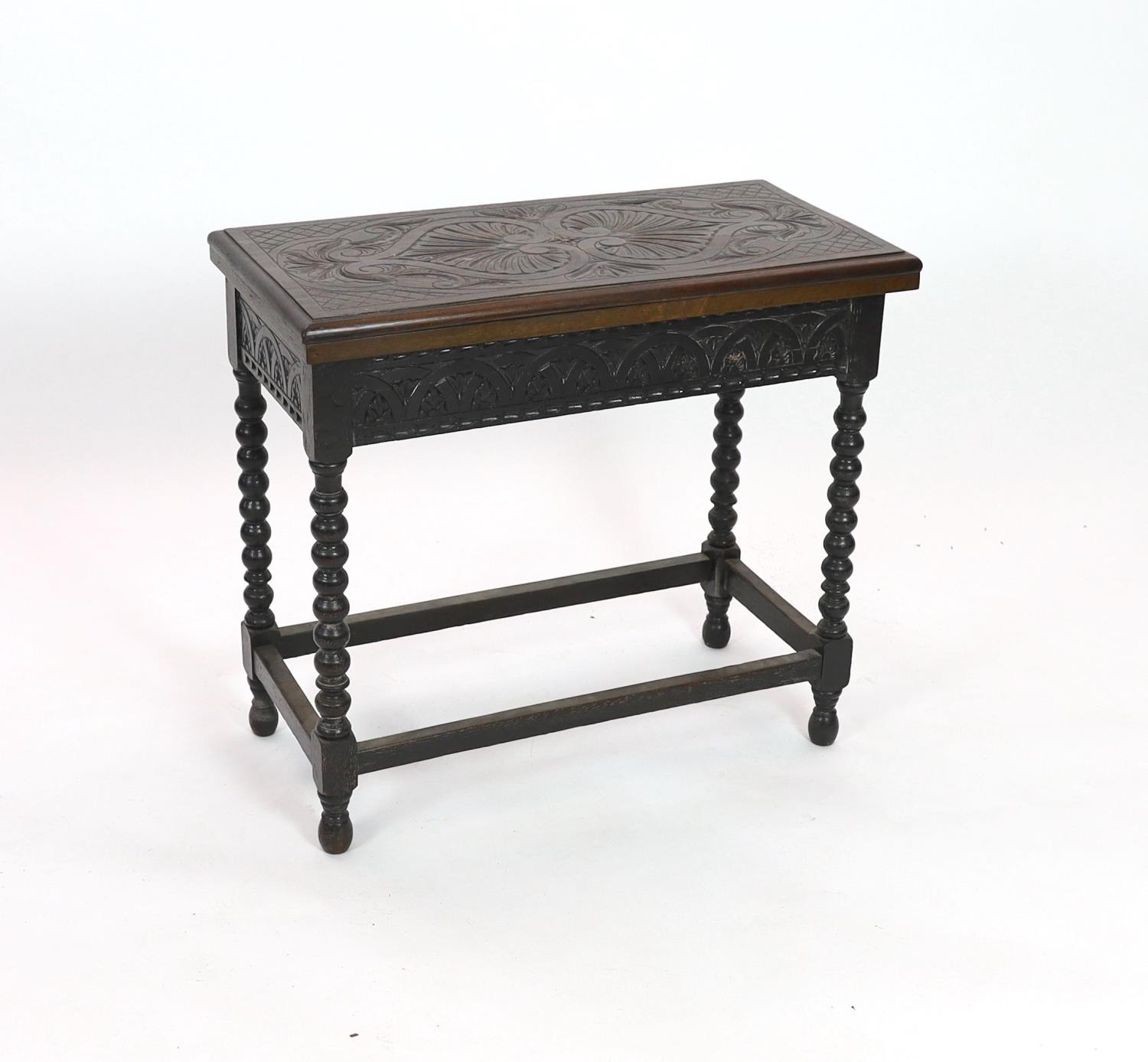 An early 20th century Jacobean revival rectangular carved oak folding card table, on bobbin turned