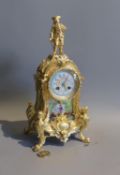 A 19th century French gilt metal and porcelain eight day mantel clock, with figural pediment, height