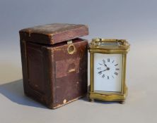 An early 20th century French lacquered brass carriage timepiece, of serpentine form, in red