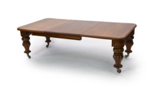 A mid Victorian mahogany extending dining table, on fluted baluster legs and spoked brass castors,