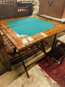 An Edwardian marquetry inlaid mahogany folding games table by W. Thornhill & Co., London, the