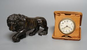 A bronze lion and Tiffany travelling watch, in tan leather case,lion 16.5 cms wide.