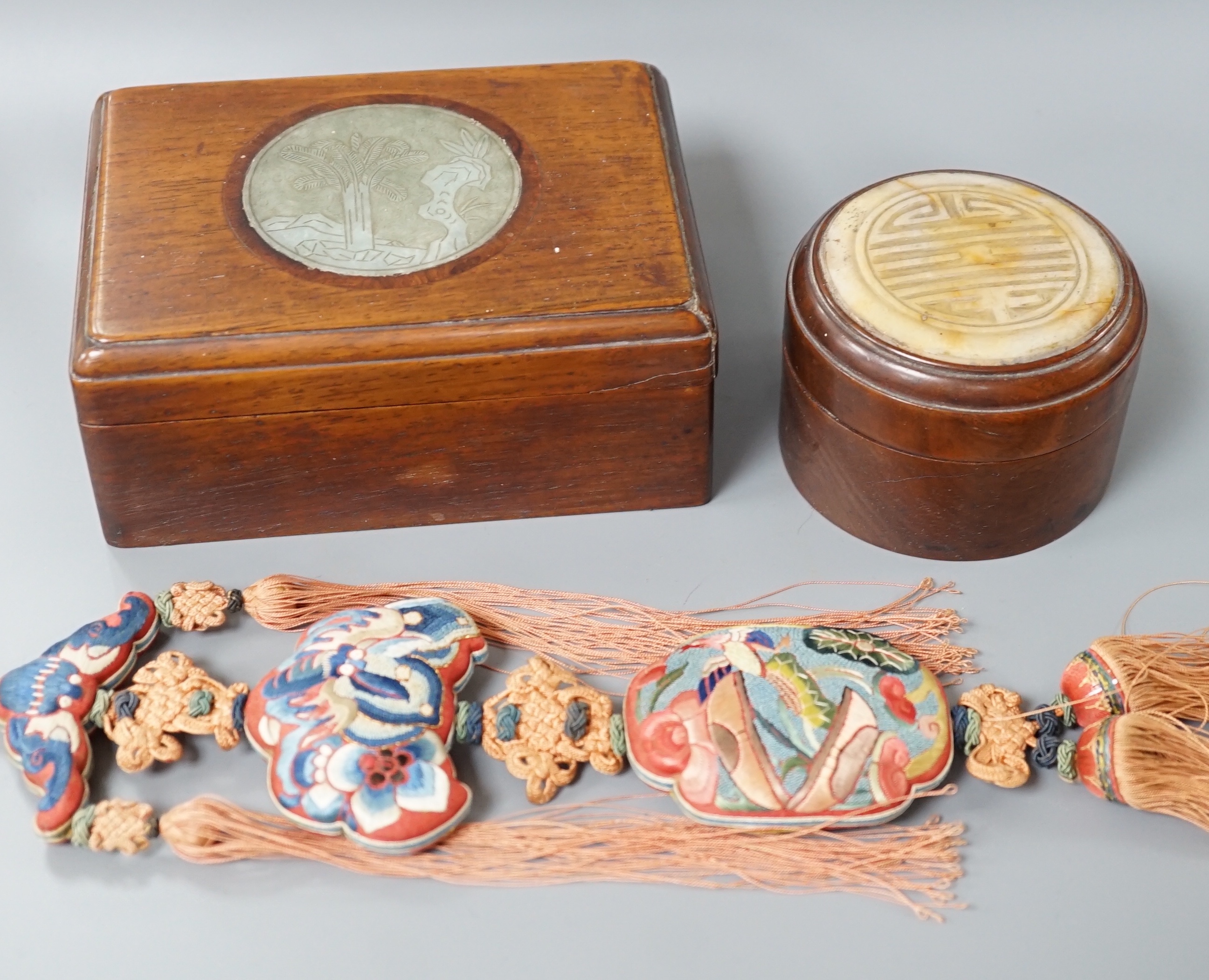 Two 19th century Chinese hardstone inset hardwood boxes and an embroidered amulet charm, largest box