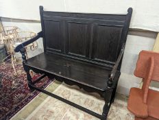 An Arts and Crafts panelled oak settle, length 109cm, depth 42cm, height 107cm