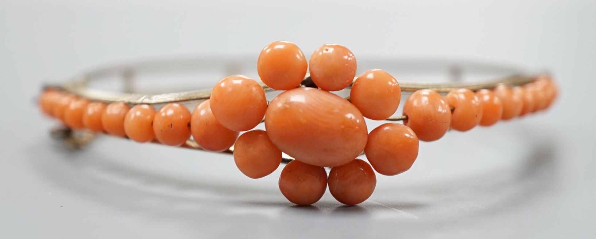 A gold plated and coral bead cluster set hinged bangle. - Image 2 of 3