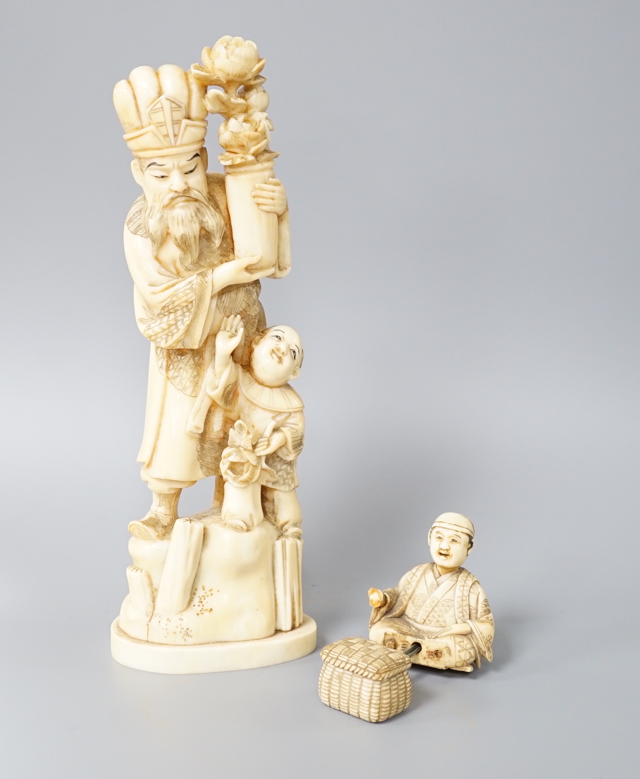 A 19th century Japanese marine ivory okimono of a bearded man and child together with a similar