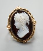 A yellow metal and oval hardstone cameo set dress ring, carved with the bust of a lady to dexter,