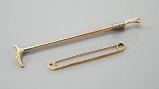 A yellow metal riding crop brooch, 69mm and a 9ct gold tie pin, gross 6.6 grams.