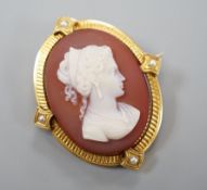 A late Victorian yellow metal and split pearl mounted oval sardonyx camel set brooch, carved with