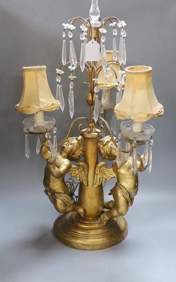 An Italian three branch gilt cherubs decorative lamp with cut glass lustre drops - 64cm high