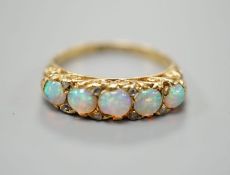A late Victorian yellow metal and graduated five stone white opal set half hoop ring, with diamond