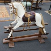 An early 20th century Ayres type dapple grey rocking horse on pine safety frame, width 130cm, height
