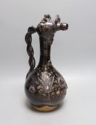 A primitive black glazed terracotta ewer with decorative headed spout and twisted handle - 38cm