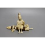 A Japanese ivory and wood okimono of a priest seated on a parasol, early 20th century, signed to a