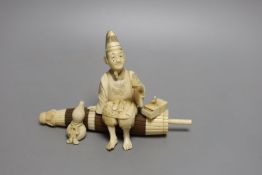 A Japanese ivory and wood okimono of a priest seated on a parasol, early 20th century, signed to a