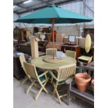 A teak garden set comprising circular table 148 cms diameter height 75 cms with 'Lazy Susan',
