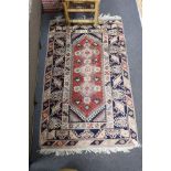 A Caucasian red ground rug and a Bokhara runner, rug 180 x 120 cms