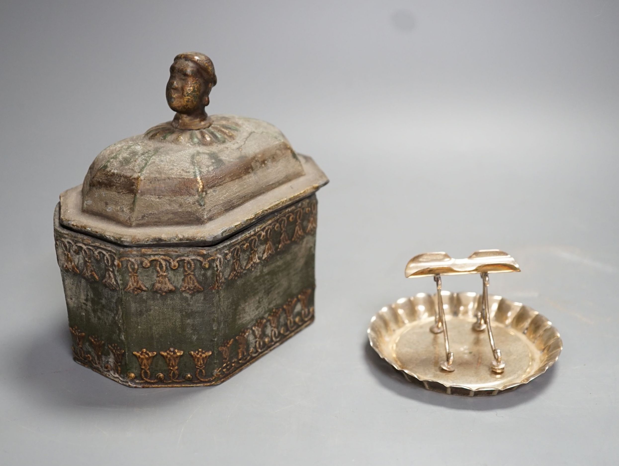 A Regency octagonal lead tobacco box, weight and cover, with slave-head finial, 14cm tall, and