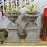 A pair of reconstituted stone campana garden urns on square plinth bases, height 90cm
