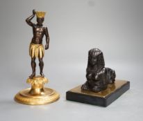 A patinated metal model of a sphinx and a bronze and gilt figure of a Nubian man. 22cm